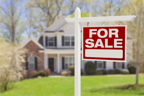 red for sale sign in front of a house