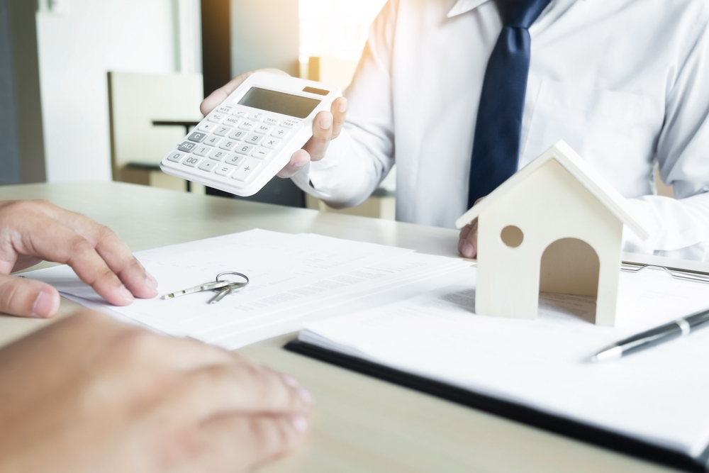 real estate agent showing numbers on calculator