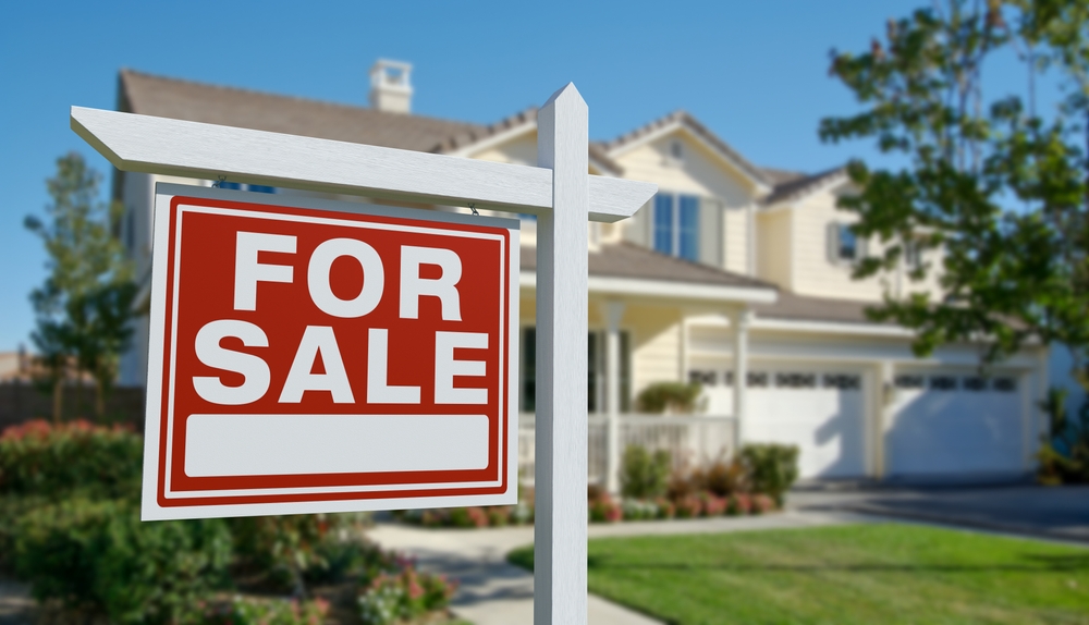 house with for sale sign in front