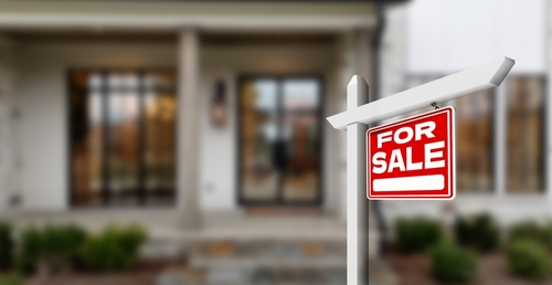 for sale sign in front of house